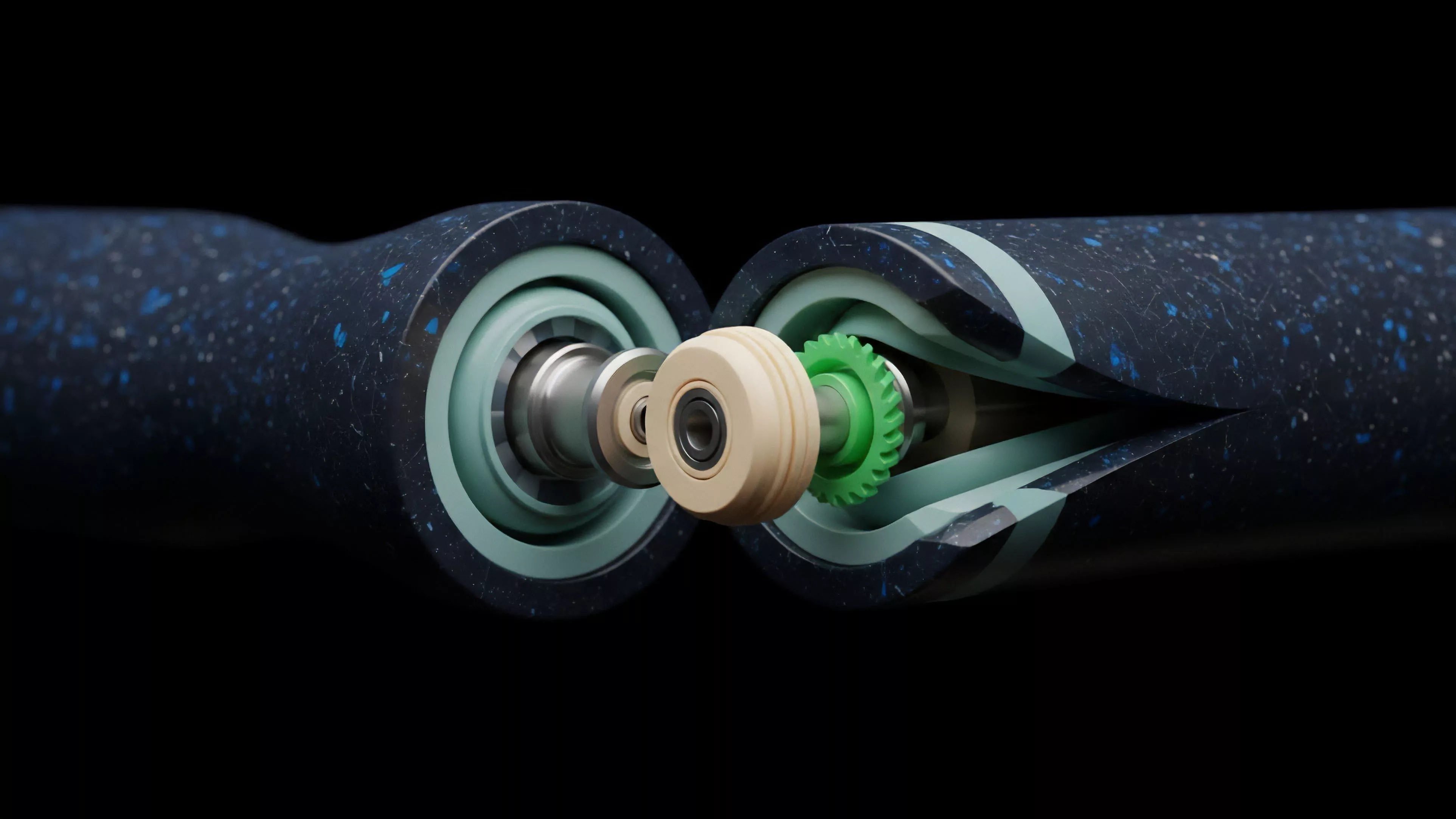 The image displays a cross-sectional view of two dark blue, speckled cylindrical objects meeting at a central point. Internal mechanisms, including light green and tan components like gears and bearings, are visible at the point of interaction