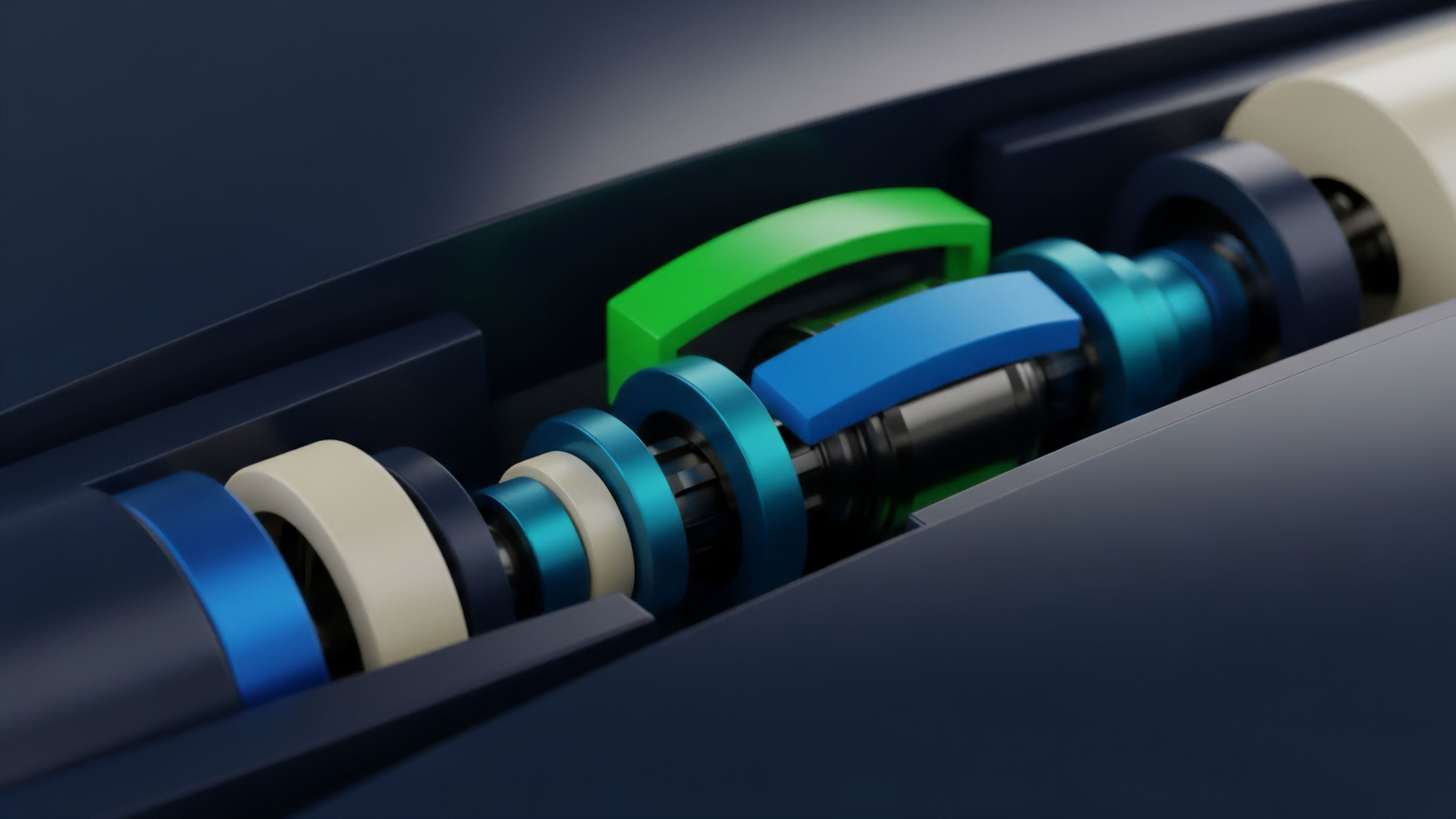 A high-angle view captures a stylized mechanical assembly featuring multiple components along a central axis, including bright green and blue curved sections and various dark blue and cream rings. The components are housed within a dark casing, suggesting a complex inner mechanism